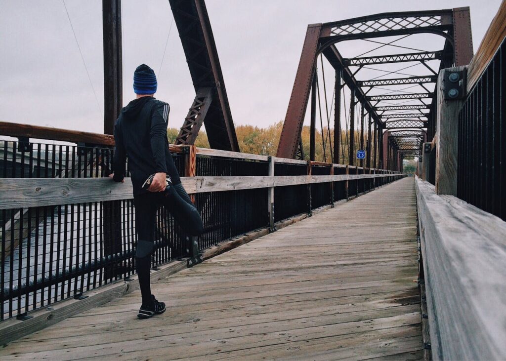 Men performing Quadriceps Stretch on a bridge