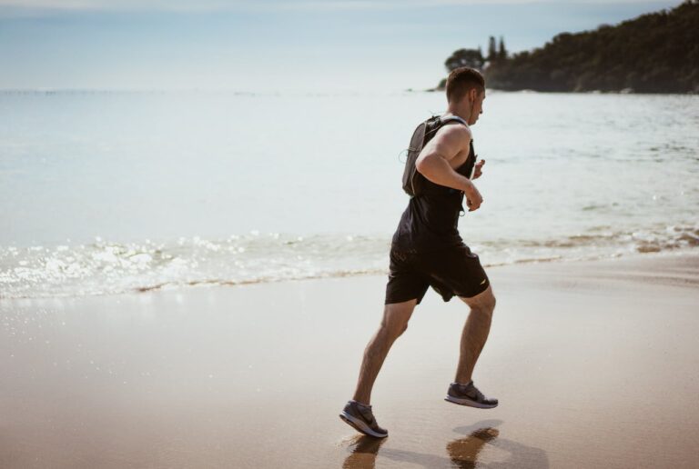 men jogging on a beach